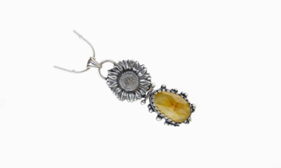 Pat Accorinti Pendant shown at an angle; sunflower imprint in fine silver and bezel set stone