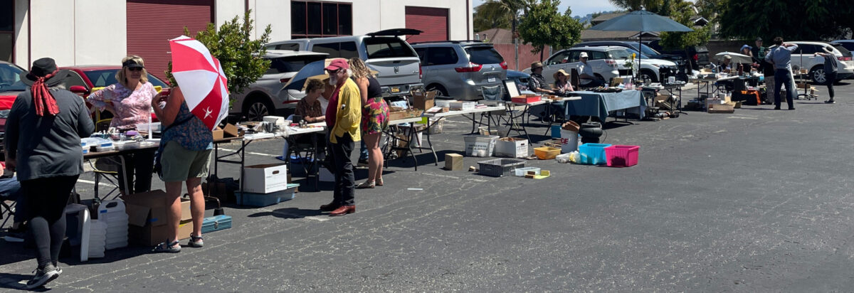 8 of the more than 10 tables in the metal arts guild swap meet with customers and for sale items on tables and on the asphalt