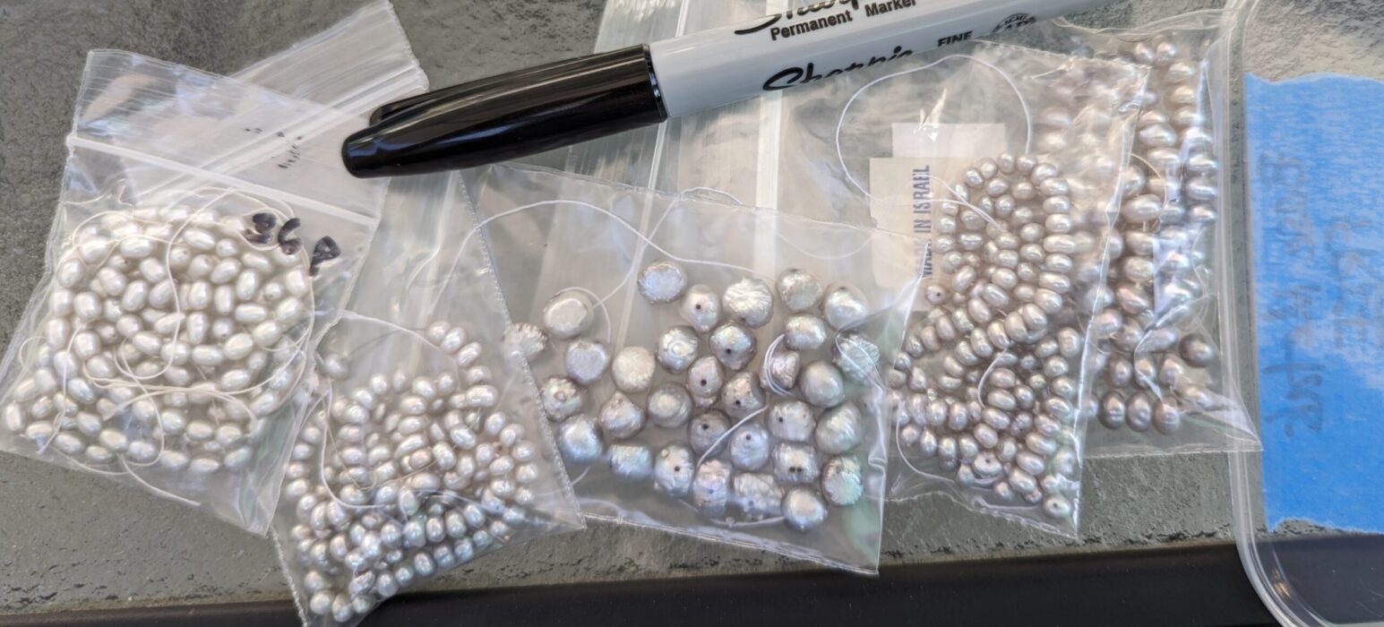 Pearls for sale at the swap meet closeup view with a sharpie for scale